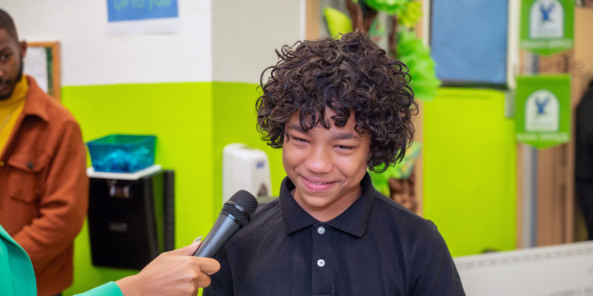 Smiling student speaking into a microphone.