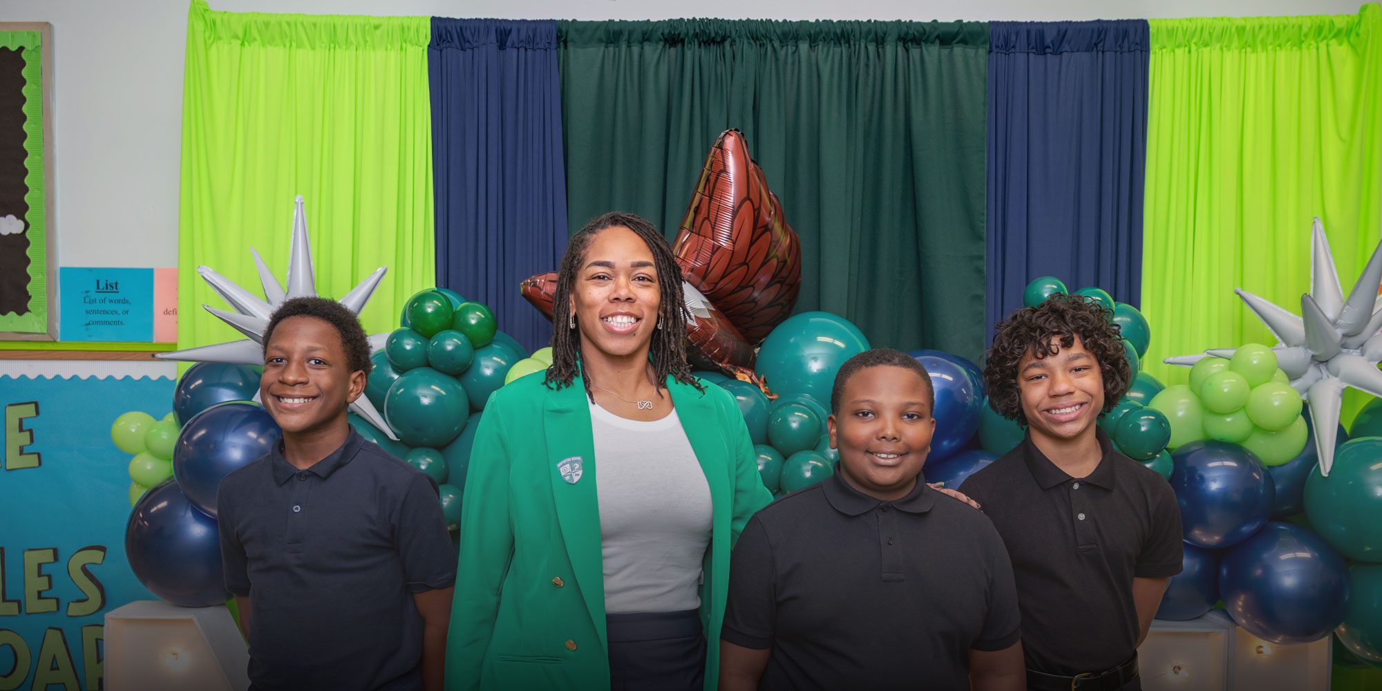 Group of smiling students standing with school leadership
