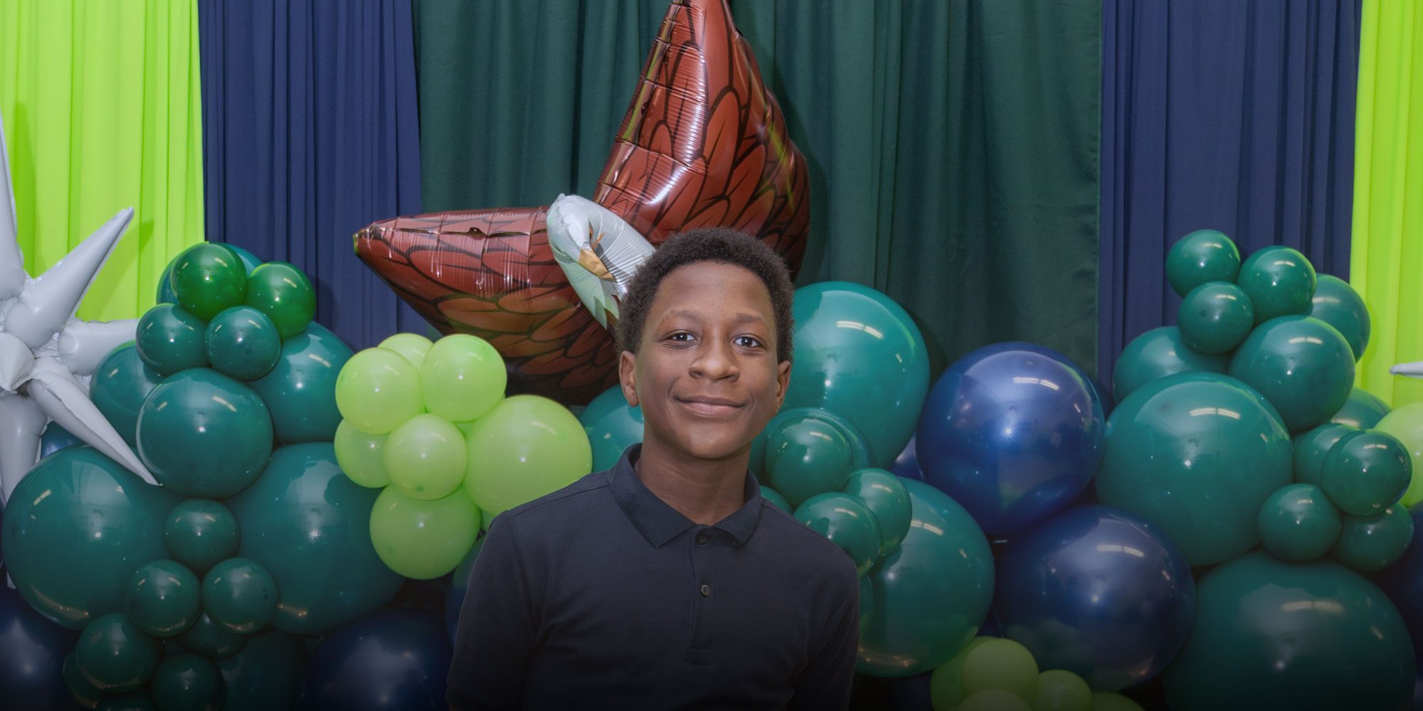 Smiling student standing in front of balloons